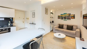 A modern living space with a kitchen, dining area, and a sofa.