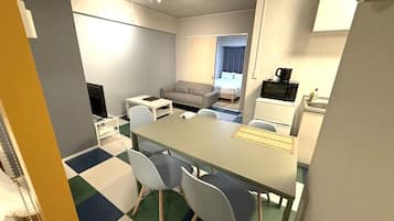 A compact hotel room with a dining area, a sofa, a bed, a kitchenette, and a TV.