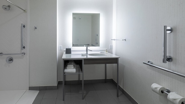 A modern bathroom with a shower, toilet, and sink. - Holiday Inn Greenville - Woodruff Road by IHG (Greenville)