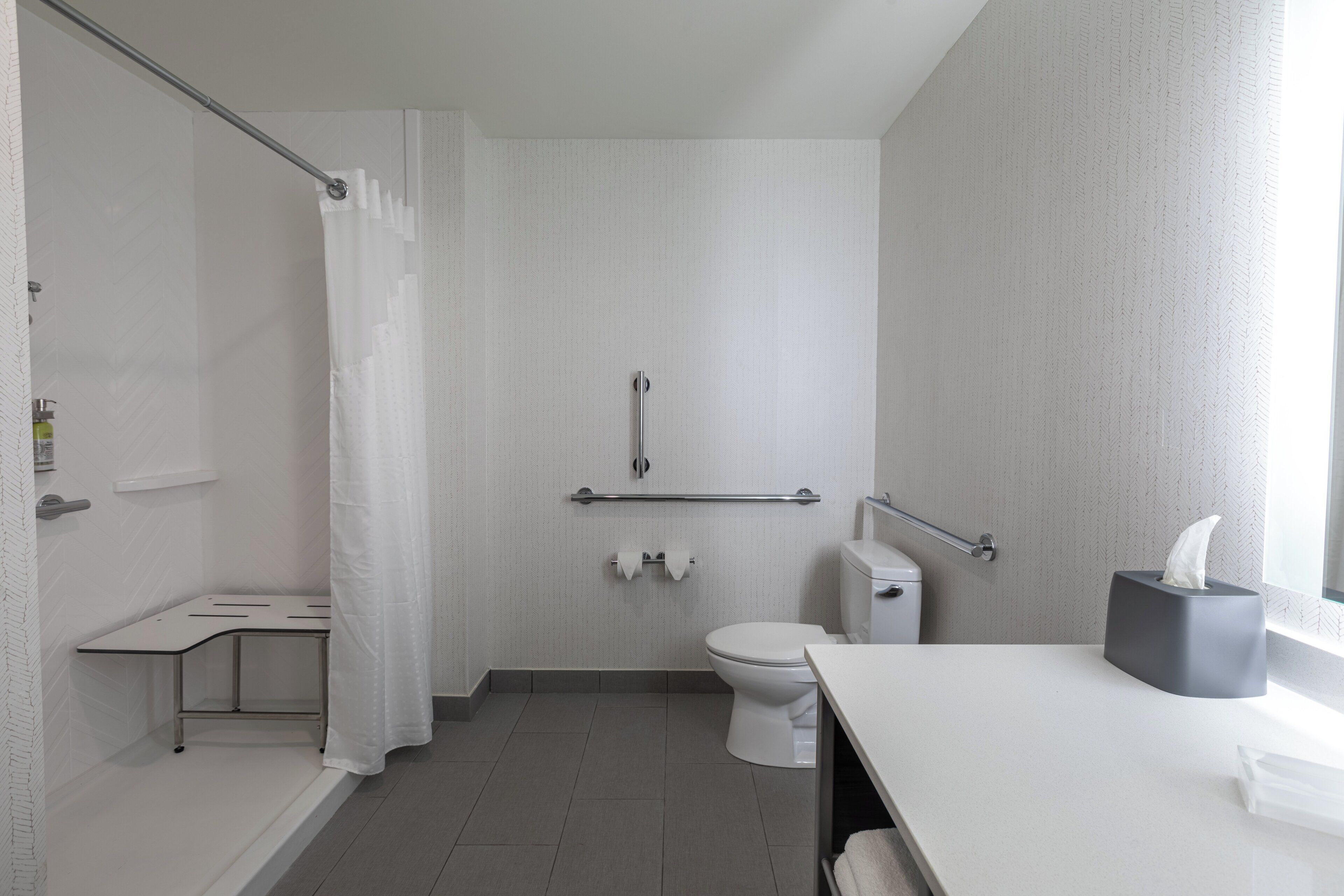 Une salle de bain moderne équipée d’une douche, de toilettes et d’un lavabo.