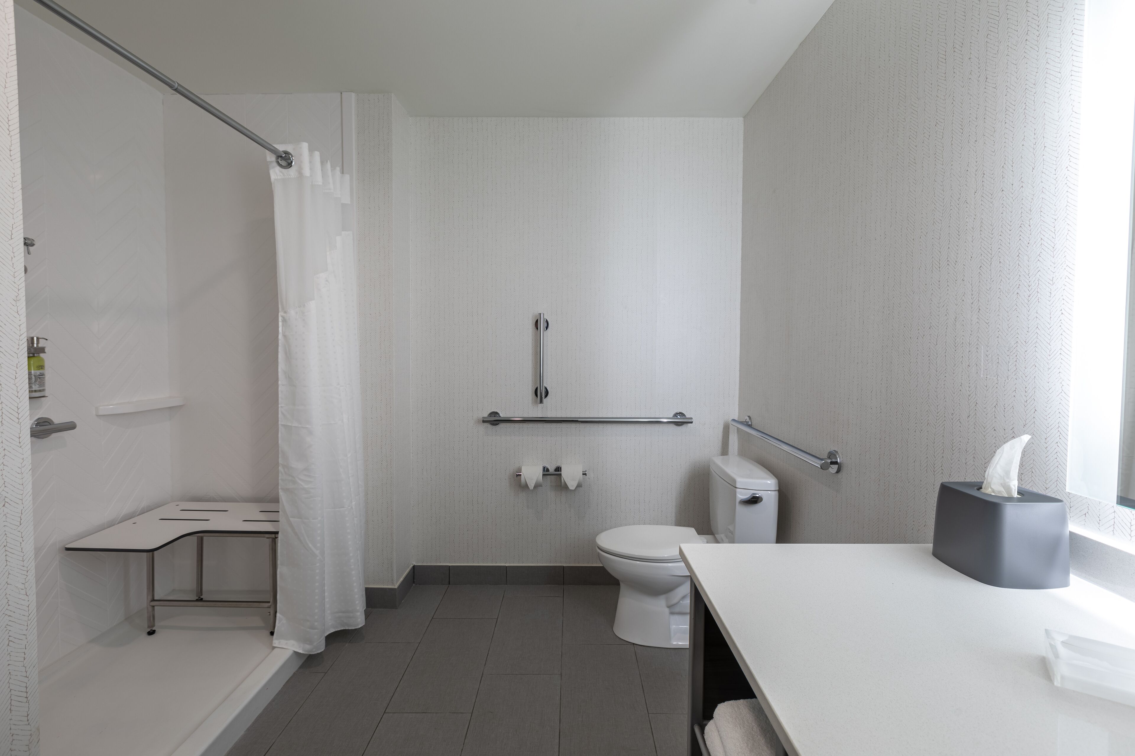 Un baño moderno con ducha, inodoro y lavamanos.