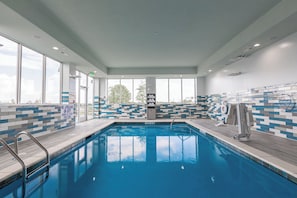 Una piscina con paredes de azulejos y una silla para salvavidas.
