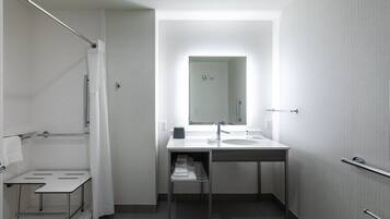 A modern bathroom with a shower, a sink, and a mirror.