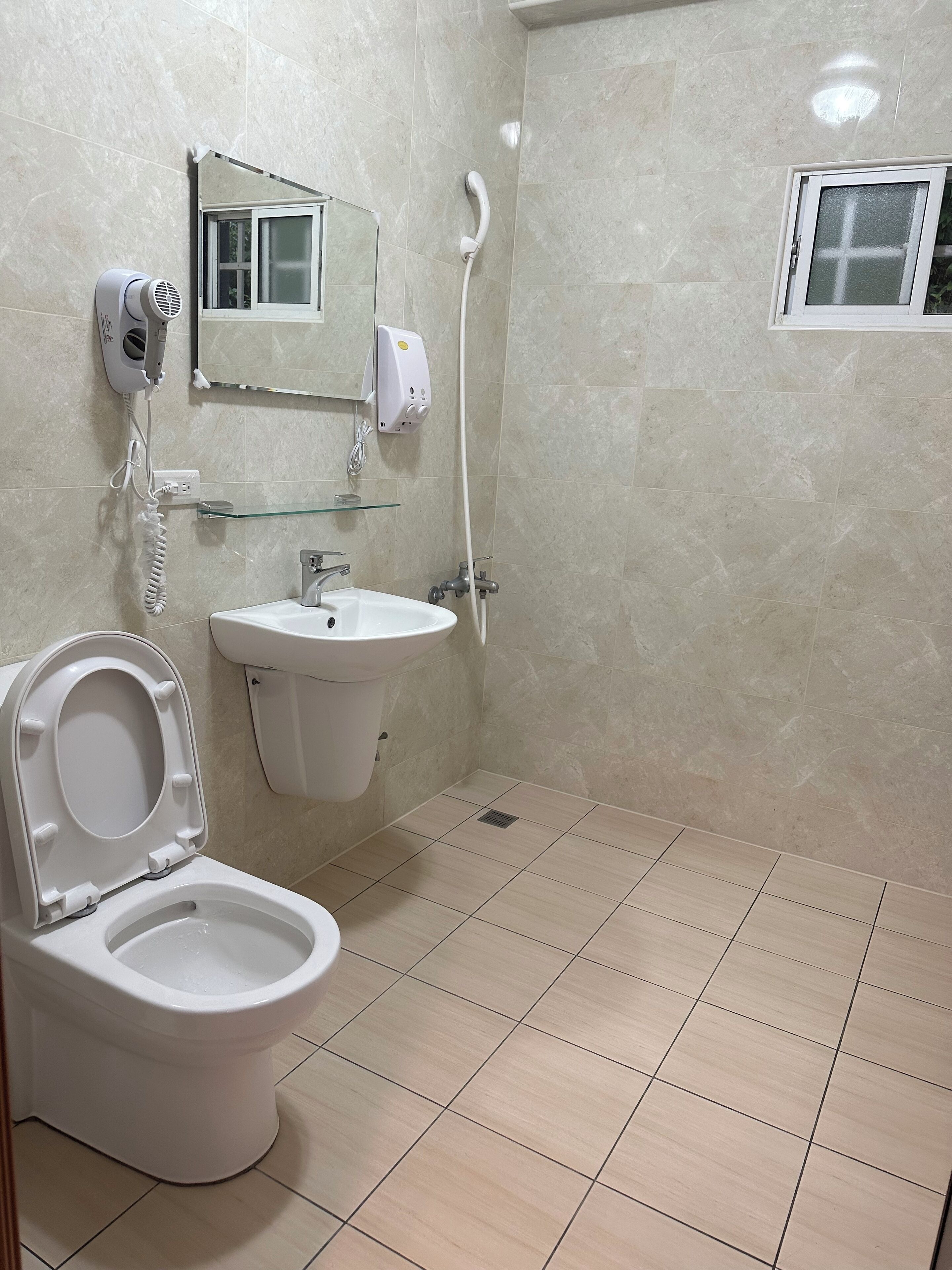 A bathroom with a toilet, sink, and shower.
