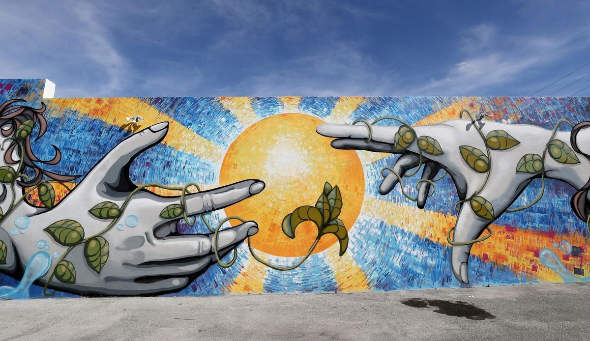 Une fresque représentant des figures abstraites et un soleil.