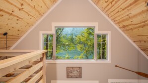 Un interior de madera con vista a un bosque por una ventana.