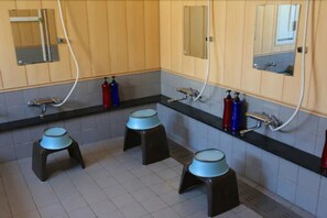 Kombinasi shower/bathtub, sandal,  dan handuk