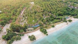An aerial view of a resort with a beach, palm trees, and a pool area. - Lumi Hotel Gili Trawangan (Gili Trawangan)