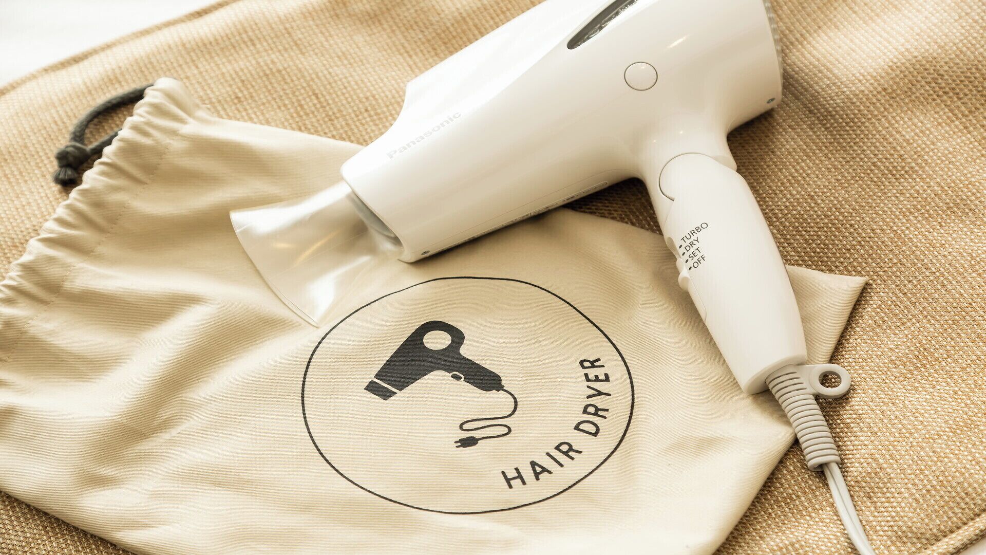 Un sèche-cheveux et un tissu beige orné d’un logo.