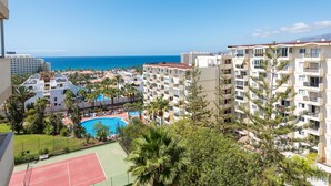Et resort med flere bygninger, en swimmingpool og en tennisbane.
