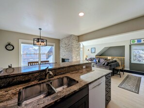 A kitchen with granite countertops, stainless steel sinks, and a dishwasher.
