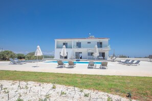 A two-story building with a swimming pool, sun loungers, and umbrellas. - Villa Sienna, Fabulous 6bdr Protaras Villa (Protaras)