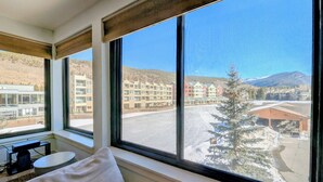 Une chambre dotée de grandes fenêtres donnant sur une station de ski.