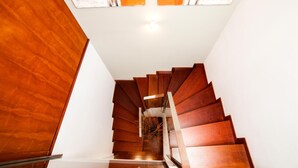 Una scala a chiocciola in legno con soffitto in vetro e vista sul cielo.