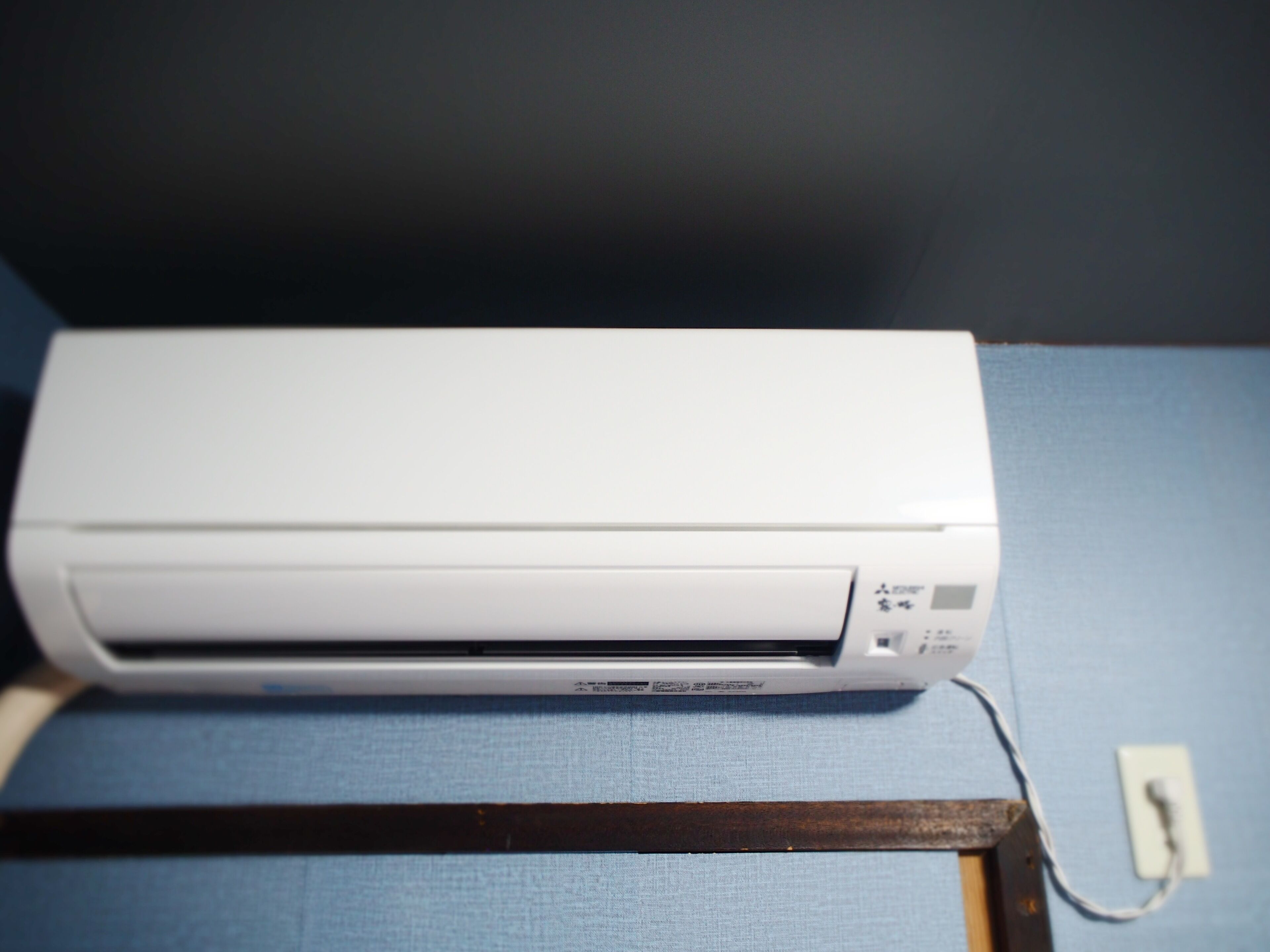 Um aparelho de ar condicionado branco sobre uma superfície azul.