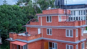 A multi-story brick building with multiple windows and balconies. - Silu Homes (Lalitpur)