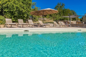 A clear blue pool with lounge chairs and umbrellas. - Holiday house TRSJA with swimming pool (Linardići)