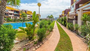 Un resort con piscina, un paseo pavimentado y varios edificios con balcones.