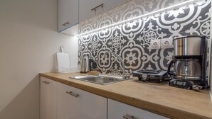 Una cocina moderna con un salpicadero estampado, electrodomésticos de acero inoxidable y encimera de madera.