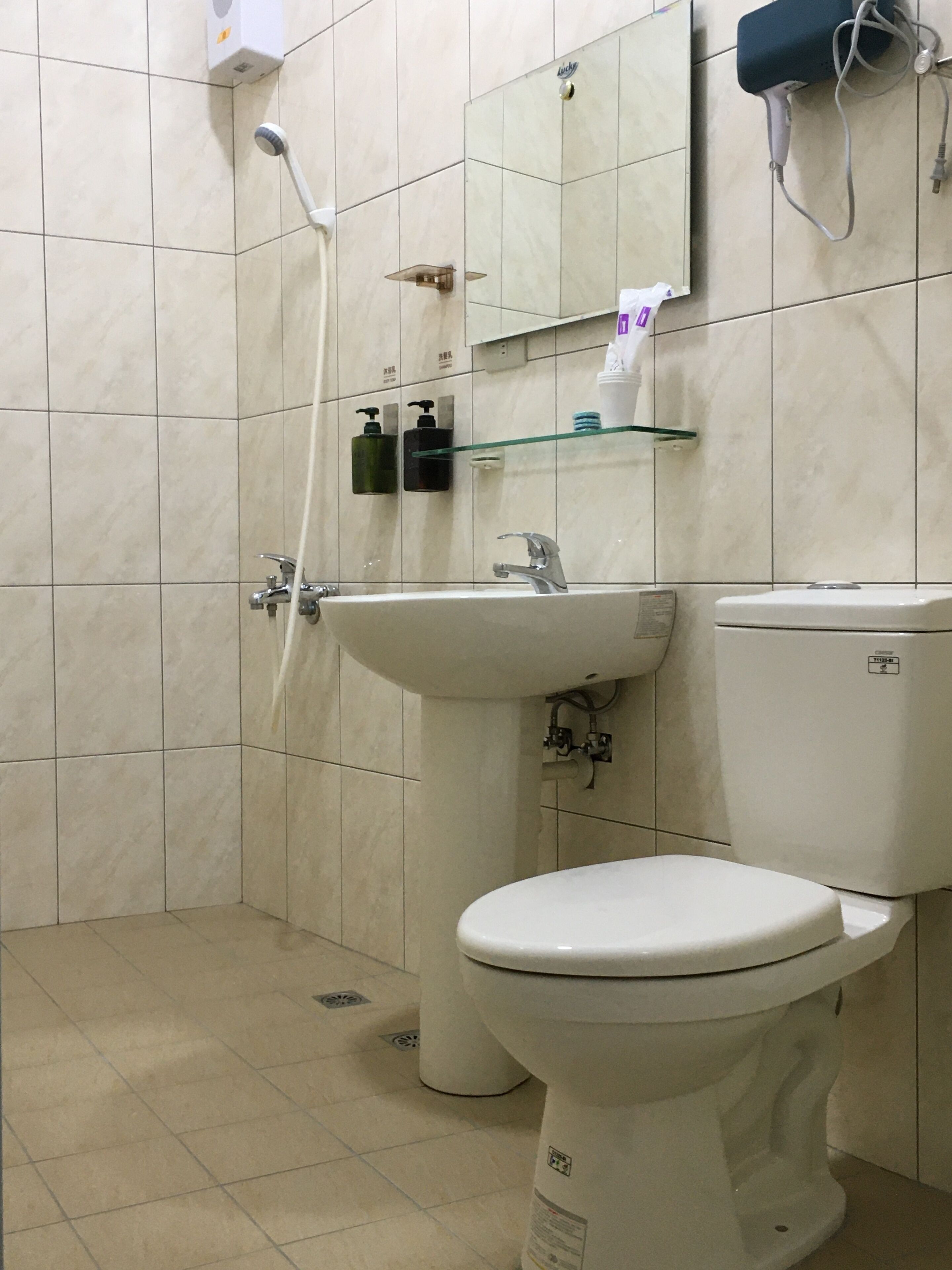 A bathroom with a toilet, sink, and shower.