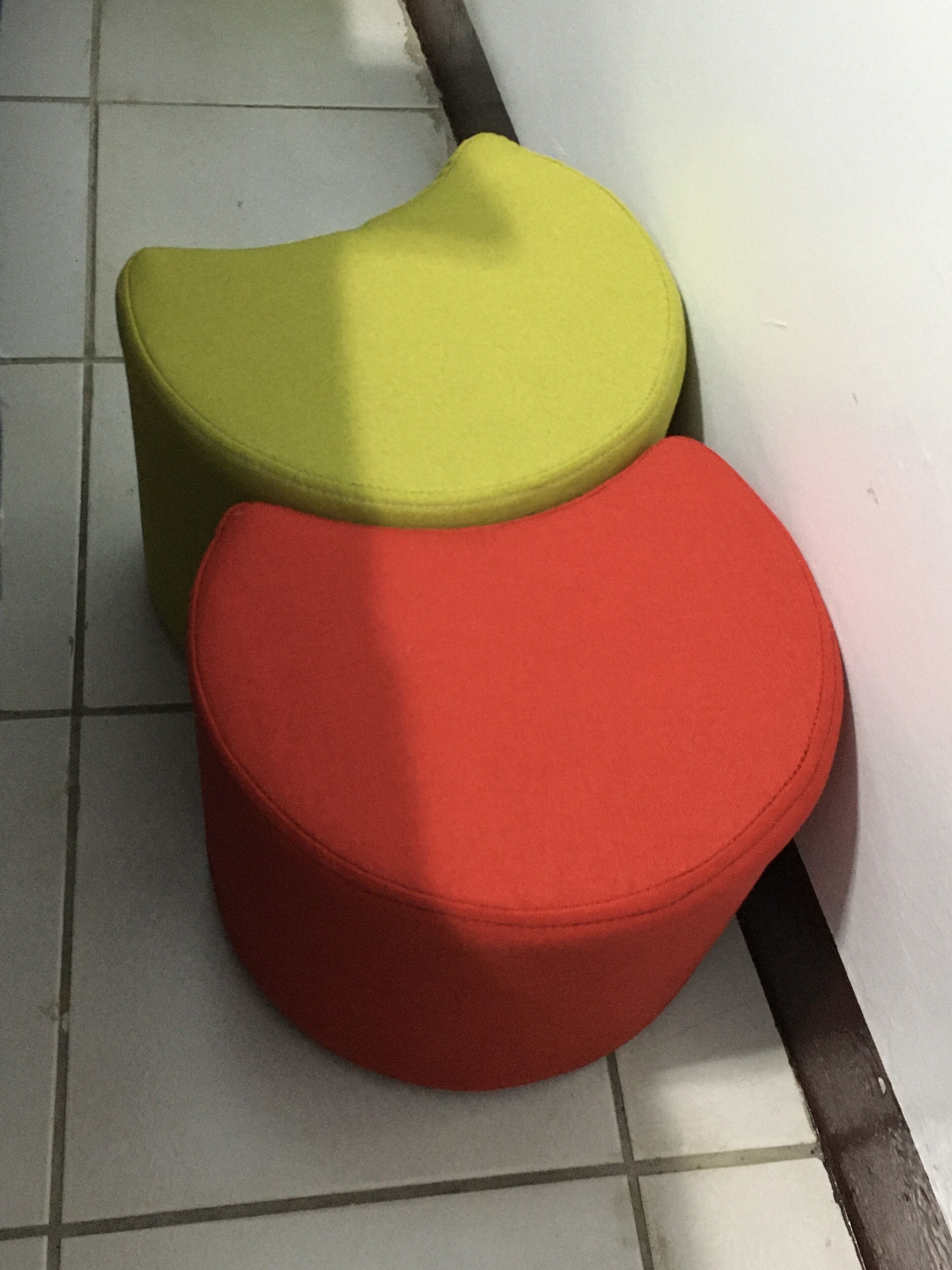 Zwei runde, gepolsterte Sitzbereiche in einem gefliesten Raum.