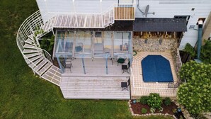 The rear of an inn with a hot tub and seating area. - Historic Inn Vacation Rental (Ashfield Colborne Wawanosh)