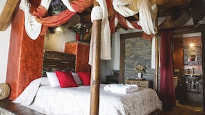 A four-poster bed with draped fabric, a stone base, and a wooden ceiling. - Casa Rural Orgullo Rural 4 estrellas (Bermellar)