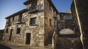 A stone building with a balcony, a staircase, and a sign that reads "Ospital de la Roca". - Casa Rural Orgullo Rural 4 estrellas (Bermellar)