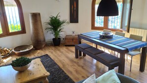 A dining area with a wooden table, benches, and a potted plant. - Bed and Breakfast La Madrugada (Còmpeta)