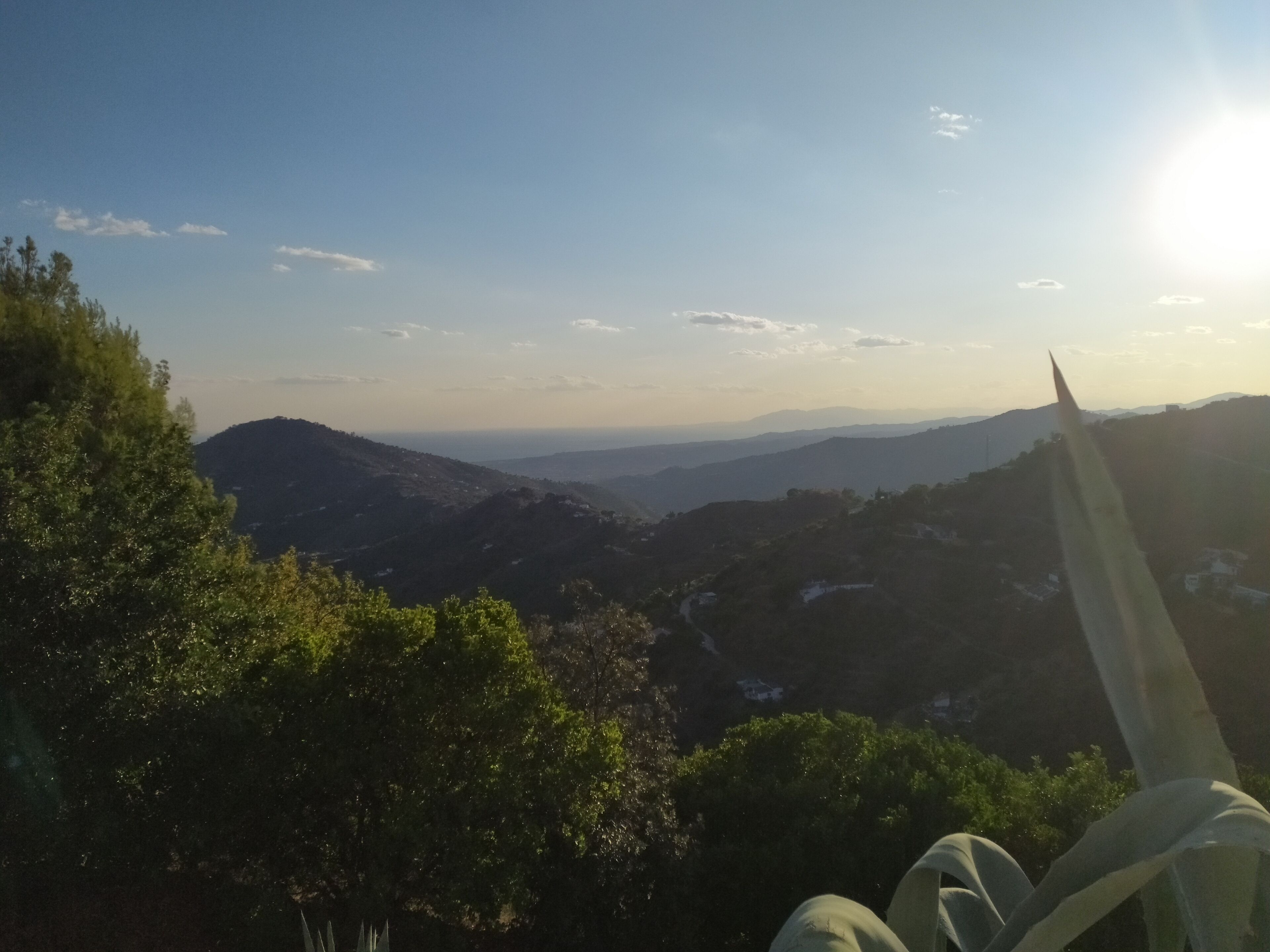 A mountainous landscape with a clear sky and a distant view of a city.