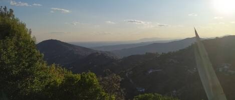 A mountainous landscape with a clear sky and a distant view of a city.