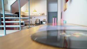 A modern kitchen with wooden countertops, a coffee machine, and hanging pendant lights. - UNICO - Art & Decor (Ostuni)