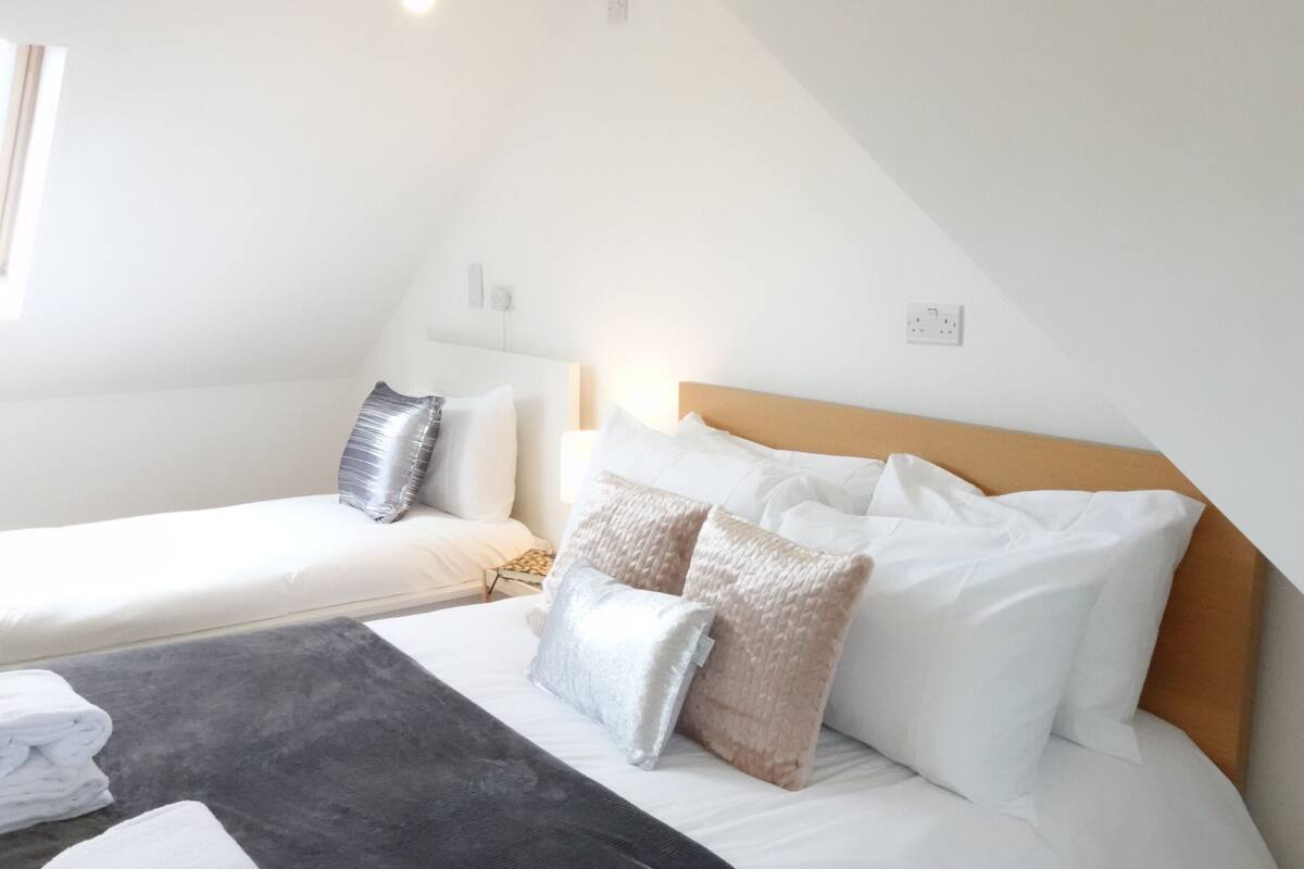 Ein Schlafzimmer mit zwei Betten, einem Fenster und einem Holzkopfende.