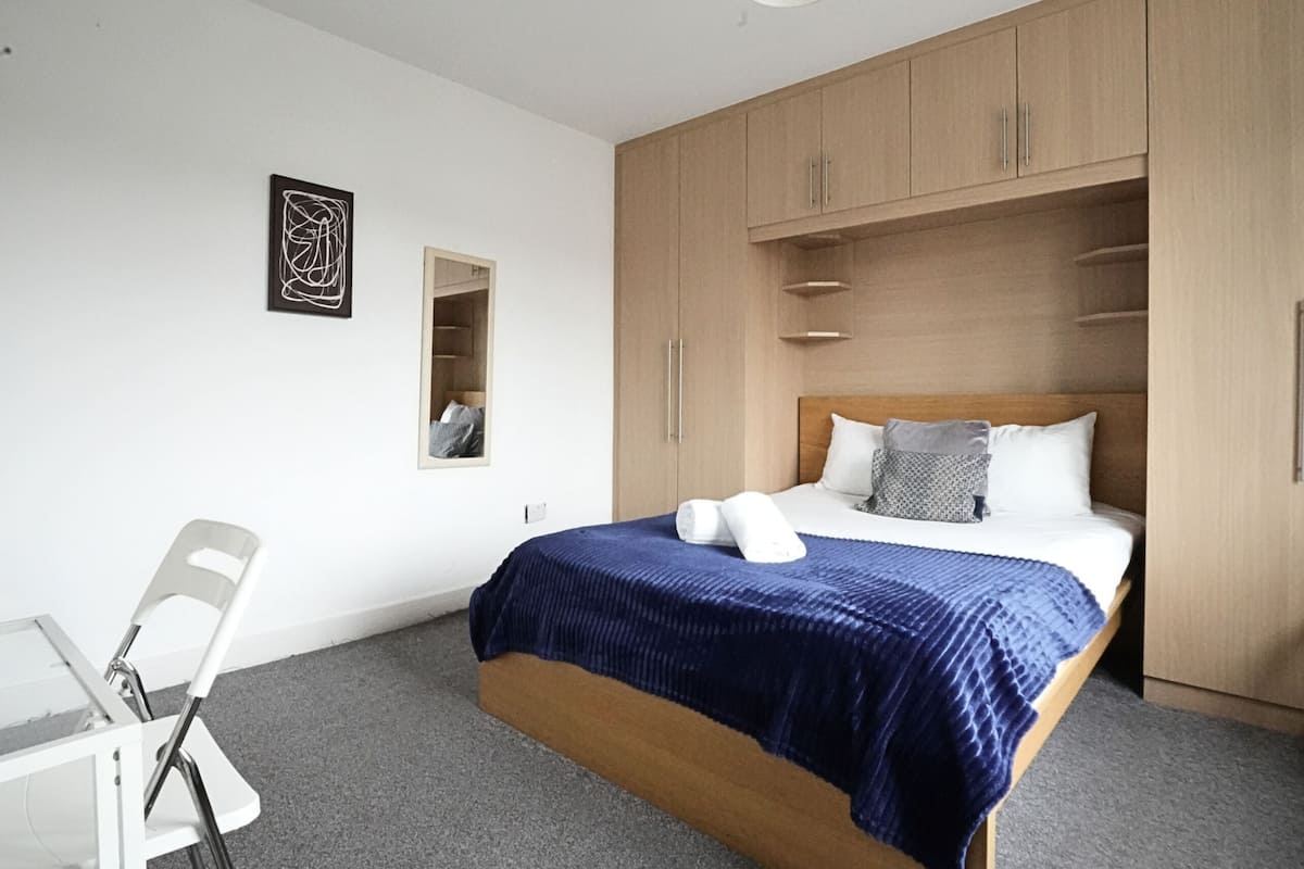 Ein Schlafzimmer mit einem Bett, einem Schreibtisch und einem Stuhl.