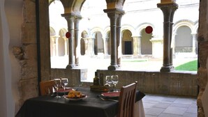 Une table dressée pour deux personnes, avec vue sur une cour extérieure.