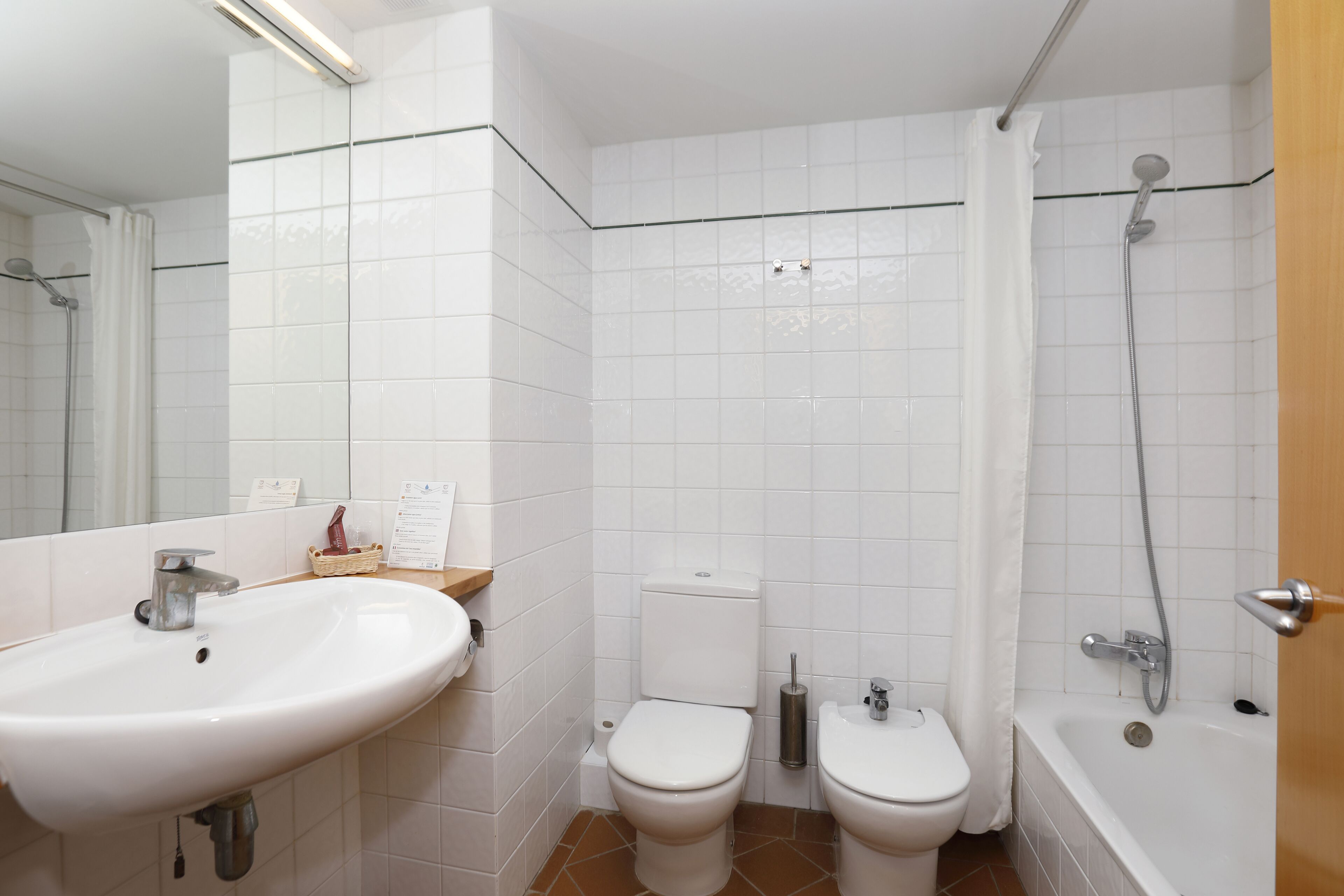 A bathroom with a sink, toilet, and bathtub.