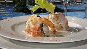 A seafood dish on a white plate with a blue tablecloth.