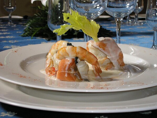 A seafood dish on a white plate with a blue tablecloth. - Monestir de les Avellanes (Os de Balaguer)