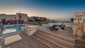 A rooftop pool area with lounge chairs, a small pool, and a view of the sea. - Grecian Villa Poseidon (Platanias)