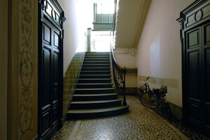 Una escalera con barandilla, una bicicleta y un suelo con diseño.