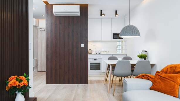 A modern living room with a sofa and a dining area with a table and chairs. - Sarah Apartments Old Town (Kraków)