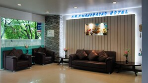 A reception area with a reception desk, two sofas, and a wall-mounted sign for KMKWANDHA HOTEL. - KM Kwanphayao Hotel (Phayao)