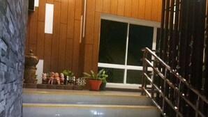 A staircase with a handrail, leading to a room with wooden paneling and a large window. - KM Kwanphayao Hotel (Phayao)