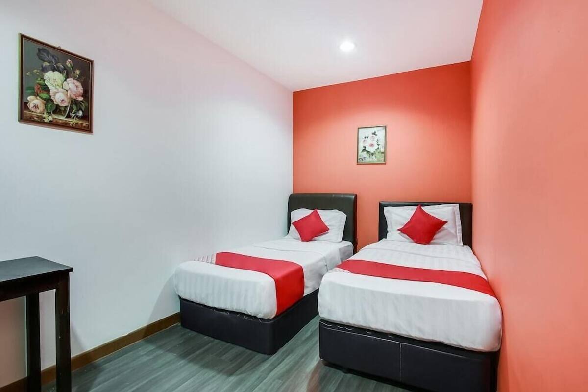 Ein Hotelzimmer mit zwei Betten, einem kleinen Tisch und einem Bild an der Wand.