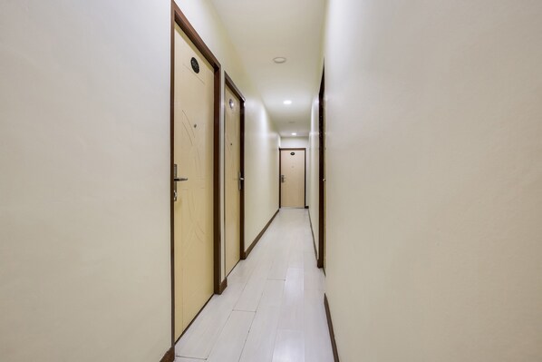 A long, narrow hallway with doors on both sides, leading to rooms. - OYO 90282 Hotel Taj (Shah Alam)