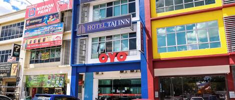 A multi-story building with a prominent 'HOTEL' sign, a 'HOTEL TAJINN' sign, and a 'HEES' LAND' sign.