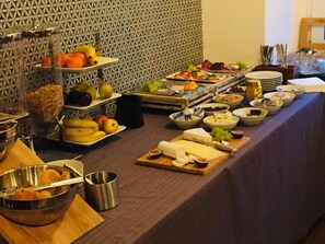 Una mesa de buffet con diversos alimentos y cubiertos.