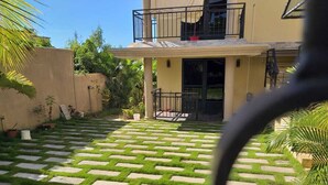 A two-story house with a paved patio and a balcony. - Modern and cozy apartment (Pereybere)