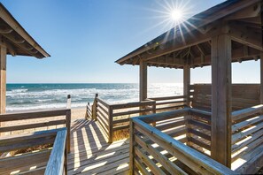 A wooden beach pavilion with a view of the ocean.