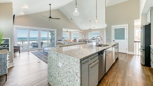 Un'ampia cucina con una grande isola, elettrodomestici moderni e vista all'esterno.